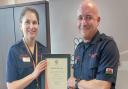 Eryl Owen receives his certificate of service from Chief Fire Officer Dawn Docx