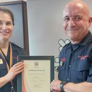 Eryl Owen receives his certificate of service from Chief Fire Officer Dawn Docx