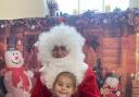 Neli, aged three, receives a gift from Father Christmas