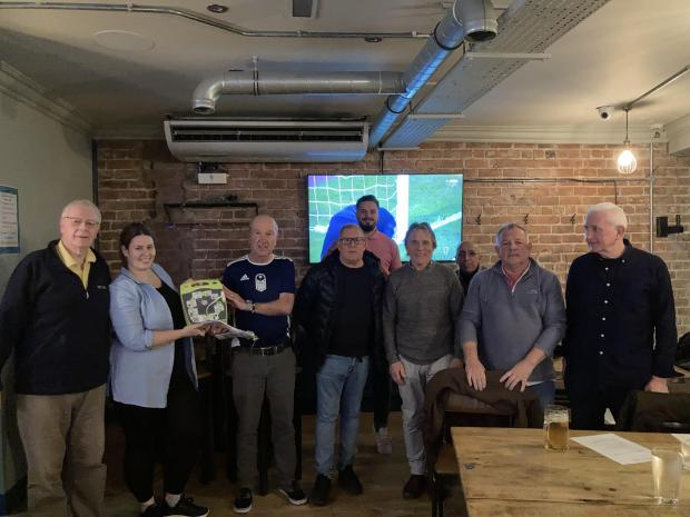 Rhyl Journal: The defibrillator and team and committee members, as well as Bar 236 manager Michael Murray and Celtic Cars director David Chadwick, who made generous donations towards the device. Photo: Alan Parr