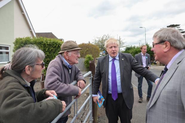Rhyl Journal: Prime Minister Boris Johnson on the campaign trail with St Asaph West candidate Peter Scott during a visit North Wales. Picture by Andrew Parsons / Parsons Media