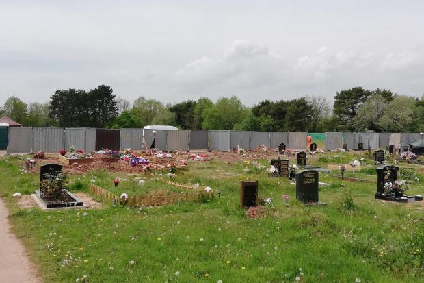 Screens were erected at the cemetery while police carried out a 