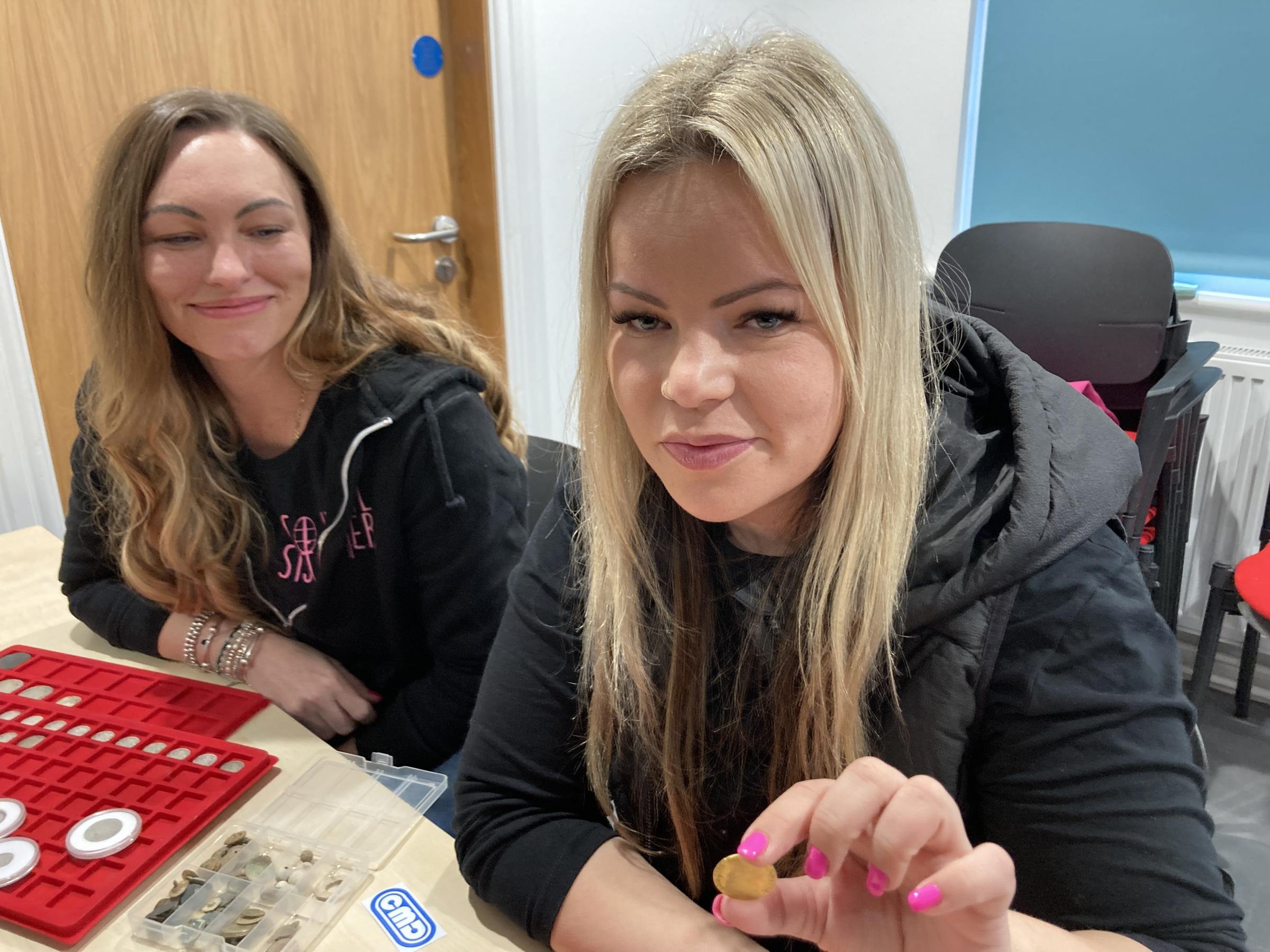 You Tube metal detectorist the Soil Sisters; Nikki Foster (left) And Sam Moss (right) at the PAS Cymru event at Storiel Bangor. Sam shows the gold guinea she found metal detecting. Image Dale Spridgeon