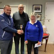 Richard Chappell (left) and Lesley Williams (right) being presented with the jubilee trophy by club captain Peter Storey (centre)