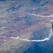 Jet fighter flying through Mach Loop in Wales.