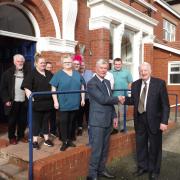Michael McEvoy welcoming Dr Pritchard, watched by other trustees and senior staff at Dolanog Care Home in Rhyl.