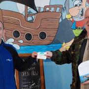 Richard Kendrick (right) picks up the 150 free tickets from SeaQuarium