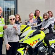 Mair Roberts presents Blood Bikes Wales with the £1,000 cheque